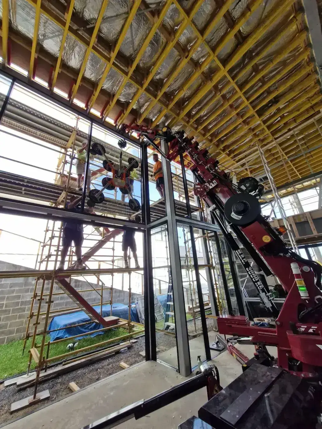 Narrowtech compact electric mini crane operating in a tight residential backyard renovation site