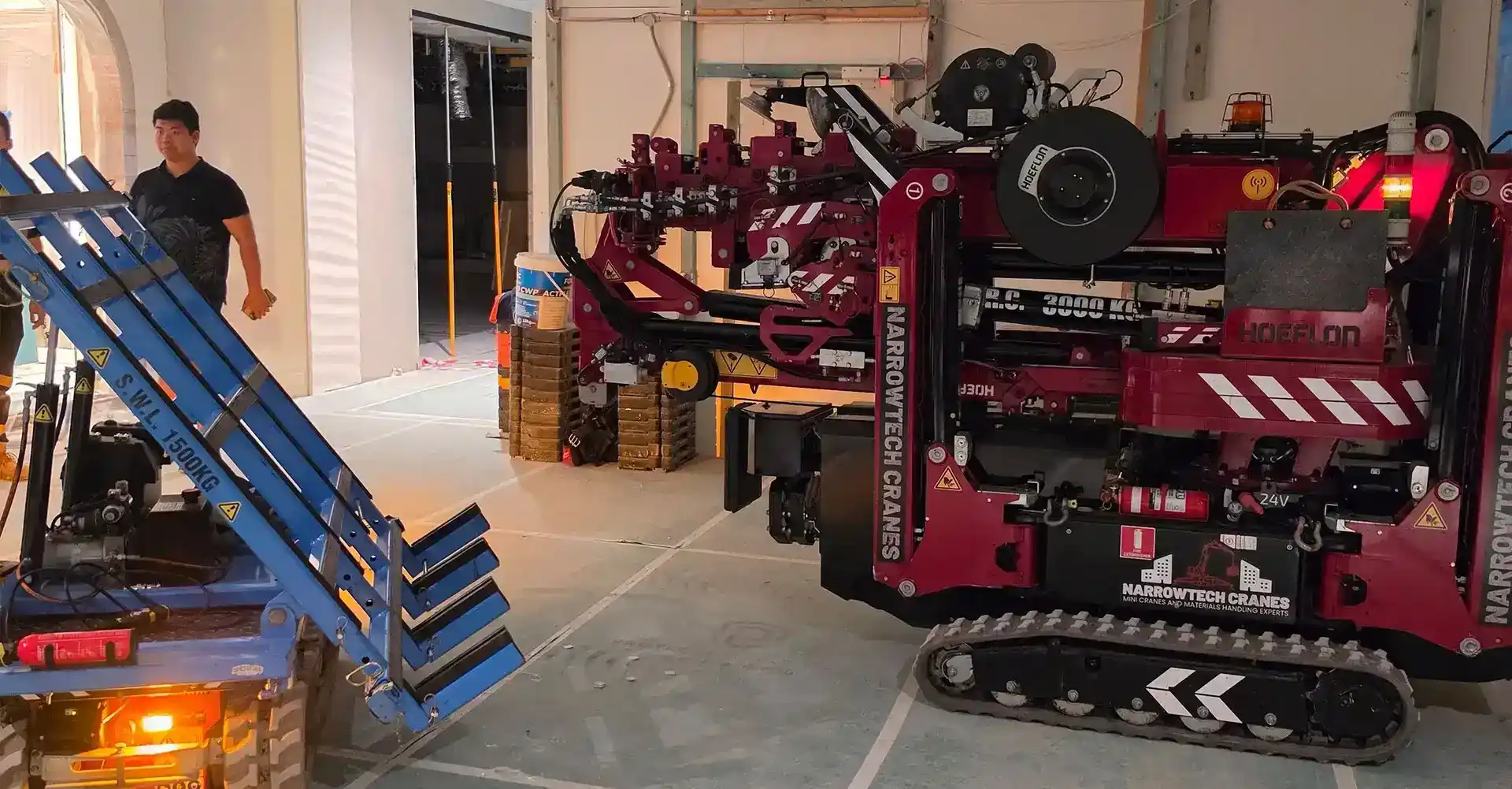 Zero-emission electric mini crane executing a quiet plant installation inside a commercial building