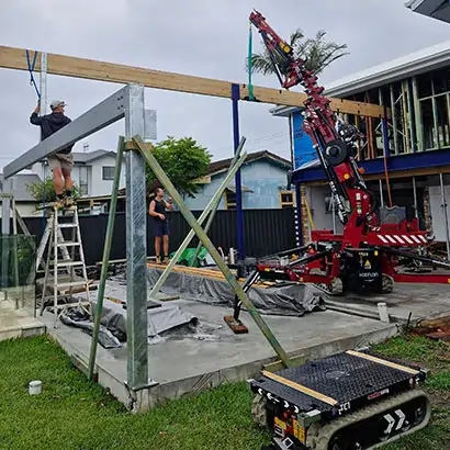 Skilled rigger team operating a mini crane on a luxury home building site