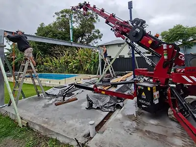 Narrowtech crane team performing a precise glass sheet installation in a tight courtyard