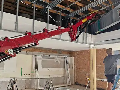 Close-up of a spider crane placing a structural steel section on a boutique build